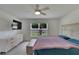 Comfortable bedroom featuring a decorated dresser and backyard view through a large window at 5547 Logan Cave Ave, Wimauma, FL 33598