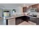 Modern kitchen with stainless steel appliances, granite countertops, and dark wood cabinets at 5547 Logan Cave Ave, Wimauma, FL 33598