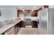 Modern kitchen with stainless steel appliances, granite countertops, and dark wood cabinets at 5547 Logan Cave Ave, Wimauma, FL 33598