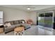 Inviting living room with gray sectional sofa and sliding glass doors leading to the yard at 5547 Logan Cave Ave, Wimauma, FL 33598