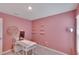 Pink office with custom shelves, modern desk and unique lighting at 5547 Logan Cave Ave, Wimauma, FL 33598