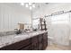 Bathroom features dual sinks, granite countertops, dark cabinetry, and decorative shower curtain at 5609 Arnie Loop, Lakewood Ranch, FL 34211