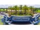 Elegant community entrance sign with palm trees and a scenic view of the golf course and water at 5609 Arnie Loop, Lakewood Ranch, FL 34211
