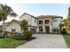 Beautiful two-story home featuring a balcony, stone accents, a brick driveway, and manicured landscaping at 5609 Arnie Loop, Lakewood Ranch, FL 34211