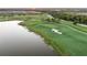 Scenic aerial view of a lush golf course with a tranquil lake at sunset at 5609 Arnie Loop, Lakewood Ranch, FL 34211
