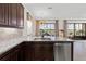 Gourmet kitchen offering stainless steel appliances, dark cabinetry, and scenic backyard views at 5609 Arnie Loop, Lakewood Ranch, FL 34211
