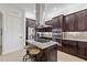 Gourmet kitchen with stainless steel appliances, dark wood cabinetry, and granite counters at 5609 Arnie Loop, Lakewood Ranch, FL 34211