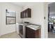 Well-equipped laundry room features modern washer and dryer with granite counters and dark cabinetry at 5609 Arnie Loop, Lakewood Ranch, FL 34211