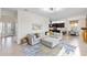 Open-concept living room, open to kitchen, with tile floors, large sectional, and plenty of natural light at 5609 Arnie Loop, Lakewood Ranch, FL 34211
