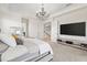 Spacious main bedroom featuring a stylish chandelier and large TV at 5609 Arnie Loop, Lakewood Ranch, FL 34211