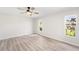 A bright bedroom features wood-look floors, a ceiling fan, and large windows at 5689 Evergreen Dr # 18, Sarasota, FL 34233