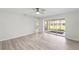 Open bedroom with gray vinyl floors, white walls, ceiling fan, and view to outdoor living space at 5689 Evergreen Dr # 18, Sarasota, FL 34233