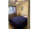 Neutral bedroom with patterned curtains, a dark blue bedspread and a wooden chair at 6324 Case Ave, Bradenton, FL 34207