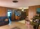 Comfortable living room with traditional wood paneling and carpet leading to a dining area at 6324 Case Ave, Bradenton, FL 34207