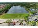 Aerial view of lake with clubhouse, golf course practice range, parking, and lush landscaping at 643 Misty Pond Ct, Bradenton, FL 34212