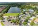 Aerial view of lake with clubhouse, parking lot, and a glimpse of the golf course at 643 Misty Pond Ct, Bradenton, FL 34212