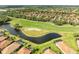 Captivating aerial view showcases a pond-side golf course and homes with screened pools at 643 Misty Pond Ct, Bradenton, FL 34212