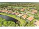 An aerial view of a home with a screened-in pool located near a golf course and a lake at 643 Misty Pond Ct, Bradenton, FL 34212