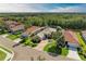 Stunning aerial view of a home with tile roof, mature trees, lush lawn, and water views at 643 Misty Pond Ct, Bradenton, FL 34212
