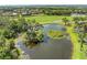 Stunning aerial view of serene pond with islands amidst lush greenery and a manicured golf course at 643 Misty Pond Ct, Bradenton, FL 34212