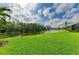 Beautiful backyard view features lush green grass and a tranquil pond surrounded by trees at 643 Misty Pond Ct, Bradenton, FL 34212