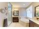 Bathroom with dual sinks, soaking tub, granite counters, walk-in shower, and dark wood cabinets at 643 Misty Pond Ct, Bradenton, FL 34212