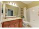 Well-lit bathroom showcases granite countertop, cherry cabinets, shower-tub combo, and tile flooring at 643 Misty Pond Ct, Bradenton, FL 34212