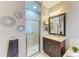 Modern bathroom featuring a glass-enclosed shower, granite countertops, and decorative mirrors at 643 Misty Pond Ct, Bradenton, FL 34212