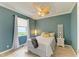Stylishly designed bedroom showcasing a ceiling fan, plush bed, bright window, and wood-look floors at 643 Misty Pond Ct, Bradenton, FL 34212