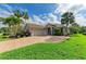 Front exterior of home with a tile roof and brick paver driveway is surrounded by lush landscaping at 643 Misty Pond Ct, Bradenton, FL 34212