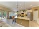 Stylish kitchen featuring granite countertops, stainless steel appliances, and a breakfast bar with woven stools at 643 Misty Pond Ct, Bradenton, FL 34212