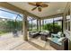 Spacious screened lanai with travertine tile, comfortable seating area, and water view at 643 Misty Pond Ct, Bradenton, FL 34212