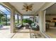 Screened outdoor patio area features travertine floors, wood ceiling fan and comfortable seating at 643 Misty Pond Ct, Bradenton, FL 34212
