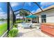 Outdoor patio area with sun loungers, hot tub, and view of the lake from screened lanai at 643 Misty Pond Ct, Bradenton, FL 34212