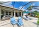 Outdoor seating area with lounge chairs and a hot tub on travertine tile under a screened lanai at 643 Misty Pond Ct, Bradenton, FL 34212