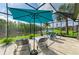 Screened lanai features a lake view with lounge chairs, patio seating, and large shade umbrella at 643 Misty Pond Ct, Bradenton, FL 34212