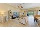 Comfortable living room with ceiling fan, stylish shelving units, and sliding glass doors to outdoor area at 643 Misty Pond Ct, Bradenton, FL 34212