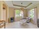 Comfortable living area featuring recessed tray ceiling, modern lighting, and large windows at 643 Misty Pond Ct, Bradenton, FL 34212