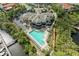 Aerial view of a resort-style pool with ample seating, surrounded by lush landscaping and waterway access at 643 Misty Pond Ct, Bradenton, FL 34212