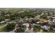 Scenic aerial view of a gray roof home with a pool surrounded by lush greenery and well-maintained landscaping at 6583 Waterford Cir, Sarasota, FL 34238