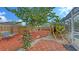 Landscaped backyard featuring decorative mulch and a cozy seating area with a chair at 6583 Waterford Cir, Sarasota, FL 34238