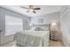Bedroom with a queen-sized bed, a ceiling fan and a window with blinds and light-blue walls at 6583 Waterford Cir, Sarasota, FL 34238