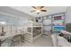 Bedroom featuring bunk beds, a desk, a ceiling fan, a shelf with decor and white floors at 6583 Waterford Cir, Sarasota, FL 34238