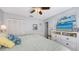 Bedroom with a queen-sized bed, ceiling fan, and a dresser plus a TV screen and white cabinets at 6583 Waterford Cir, Sarasota, FL 34238