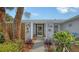 Charming entrance with brick pillars, decorative bird art, and lush plants creating an inviting approach at 6583 Waterford Cir, Sarasota, FL 34238