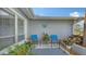 Cozy front porch with blue outdoor furniture, decorative butterfly art, and lush green plants at 6583 Waterford Cir, Sarasota, FL 34238