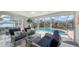 Bright sunroom/lanai with wicker furniture and clear view of the sparkling pool and lush landscaping at 6583 Waterford Cir, Sarasota, FL 34238