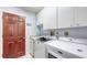 Convenient laundry room with washer, dryer, storage cabinets, and access door at 6583 Waterford Cir, Sarasota, FL 34238