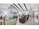 Bright living room with vaulted ceilings, exposed beams, and a large window view of the lanai at 6583 Waterford Cir, Sarasota, FL 34238