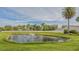 A calm pond featuring a fountain and tropical landscaping at 6583 Waterford Cir, Sarasota, FL 34238